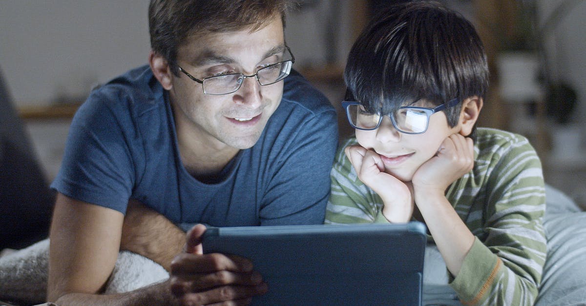 What do I need to know before watching 3D for the first time - Father and Son Looking at Tablet Screen