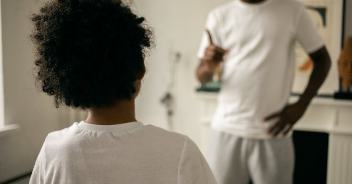 What do Majid's son and Pierrot discuss at the end? - Back view of unrecognizable black boy with Afro hair standing in front of crop anonymous dad pointing finger and scolding at home