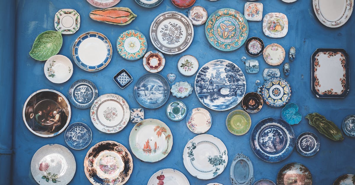 What do the different colour intros mean? - Composition of various decorative ornamental plates of different sizes and colors arranged on blue wall