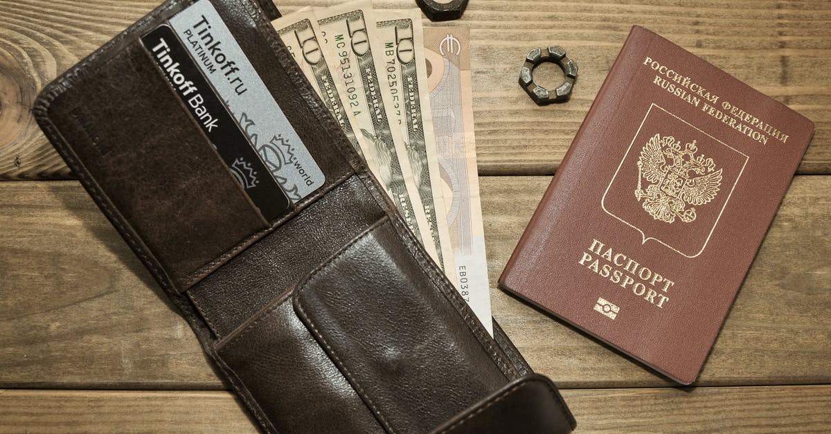 What does Helsinki say to Oslo in Russian in Money Heist, at the end of S01E12? - Photograph of a Leather Wallet with Dollar Bills Beside a Passport