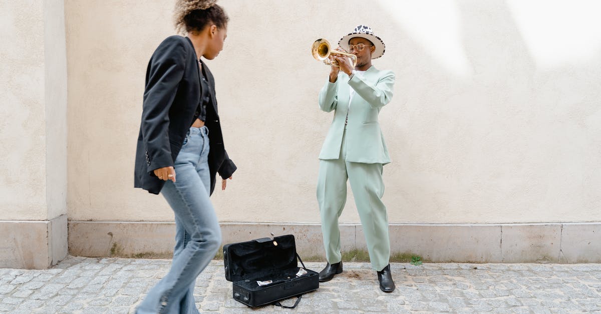 What does it mean to “give somebody a pass”? - Woman Giving Coins to the Man Playing Trumpet 