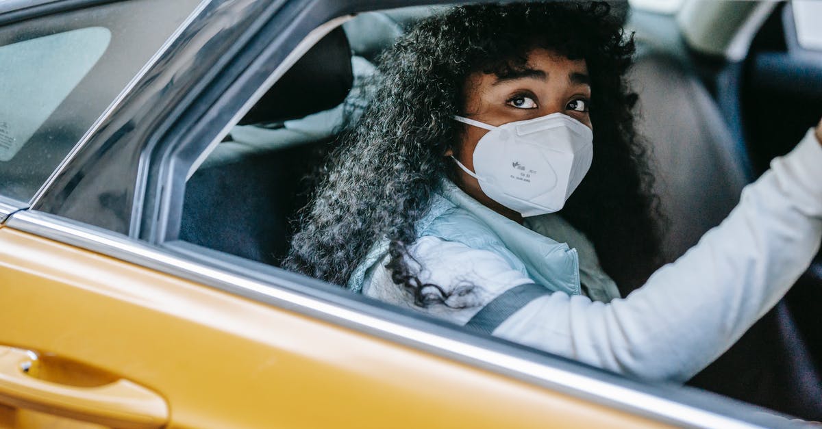 What does Travis Bickle's changed hairstyle represent in Taxi Driver? - Thoughtful African American female with dark curly hair in medical protective mask sitting in taxi and looking away in daytime