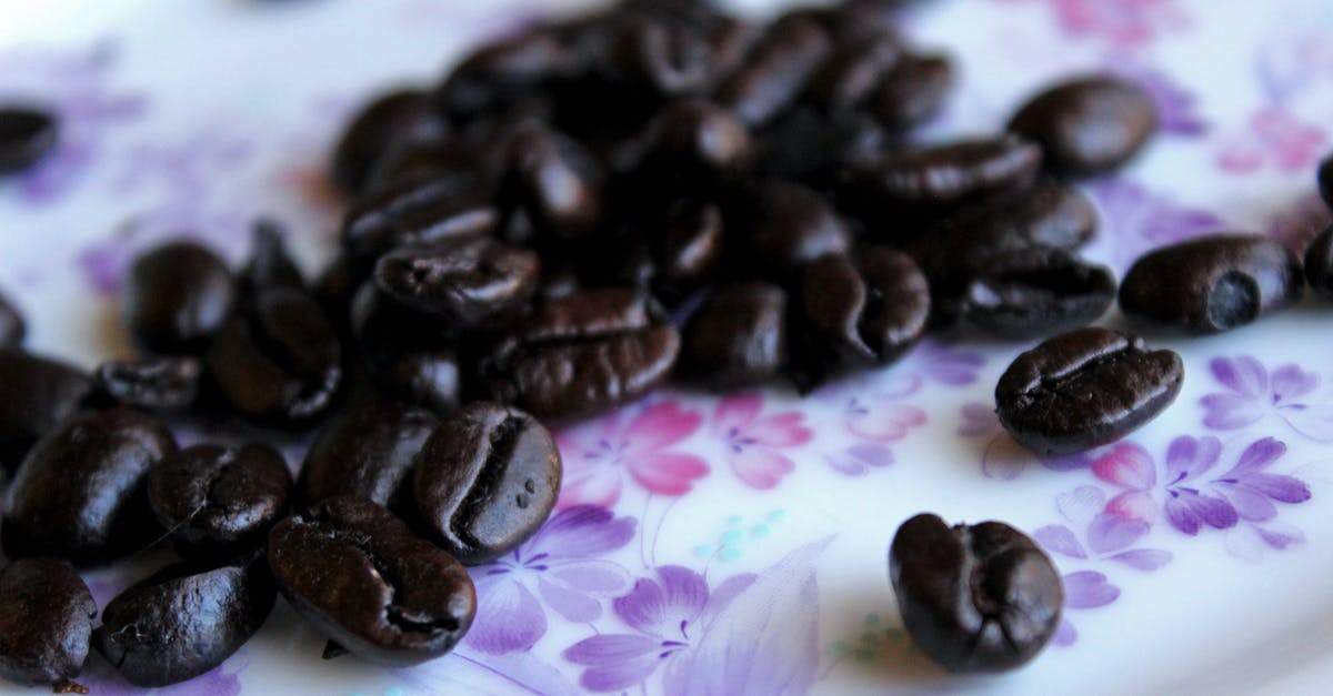 What exactly are those typical bean dishes in Italo Western? - Closeup heap of aromatic roasted coffee beans placed on tablecloth with floral ornament
