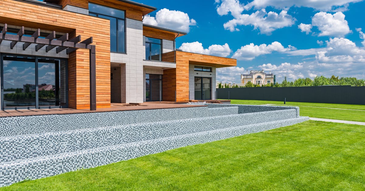 What exactly did Virginia install at the four corners of the glass window before entering into the house? - Exterior of contemporary residential house with panoramic windows glass doors and green lawn in yard on sunny day against blue sky with white clouds