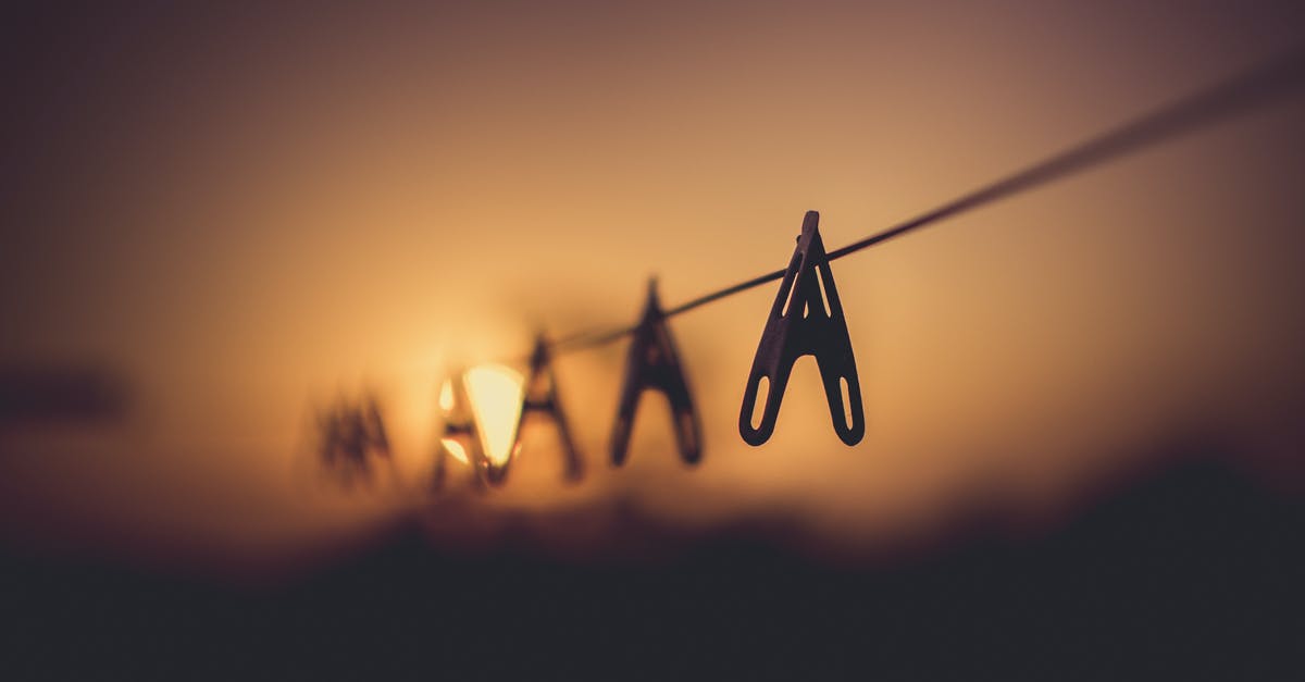 What exactly is hanging to the left in this scene? - Shallow Focus Photography of Wooden Clothes Clip on Clothes String Rack