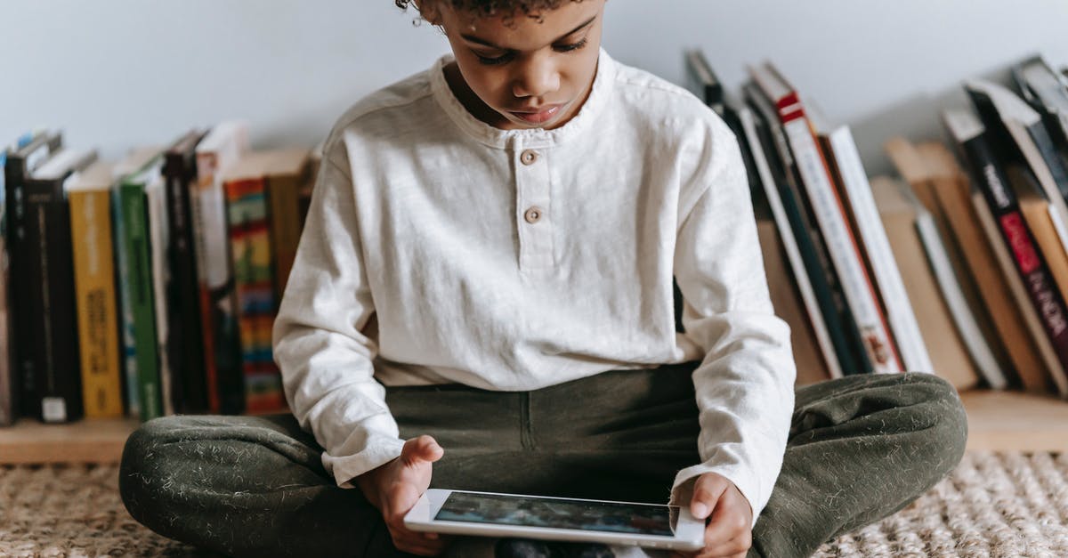 What happened to Ralph's game while he was inside the Internet? - Crop black boy browsing tablet in room