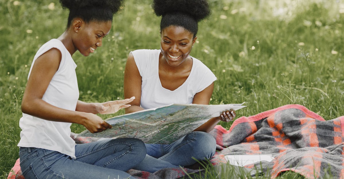 What happened to the twins? - Women Sitting on Picnic Blanket and Looking at a Map