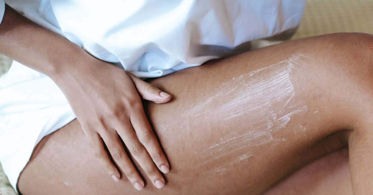 What happened to these body parts? - Woman massaging leg with lotion in bedroom