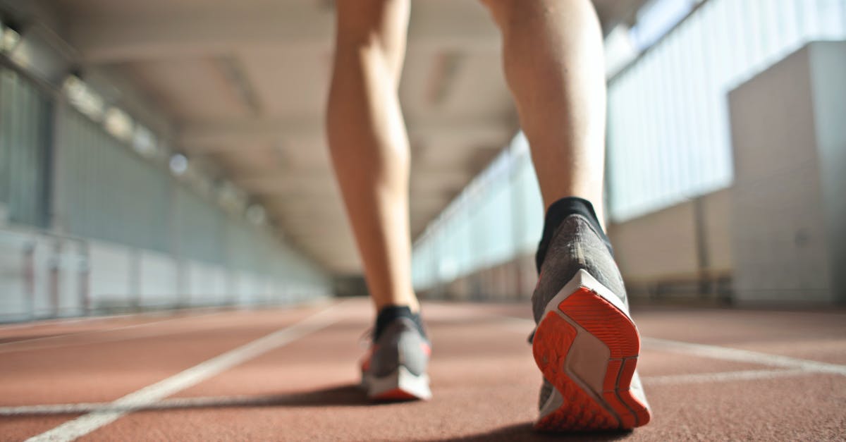 What happened to these body parts? - Fit runner standing on racetrack in athletics arena