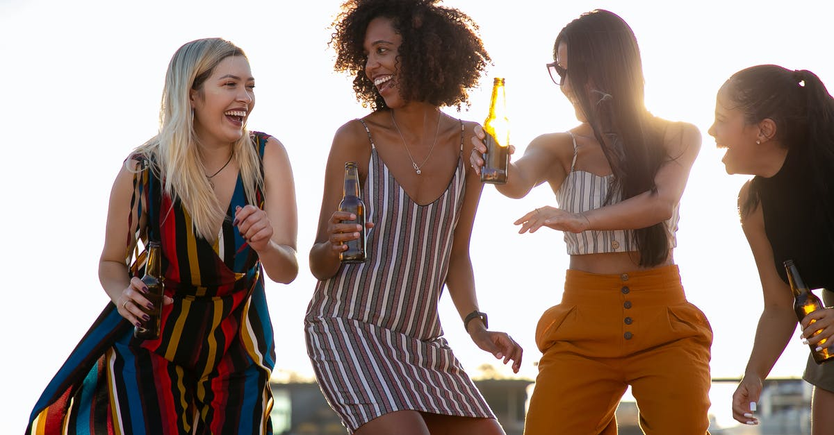 What is funny about "Can I have a chocolate donut and a bottle of beer"? - Group of cheerful young multiracial ladies laughing and dancing with beer bottles in hands during summer party on rooftop on sunny day