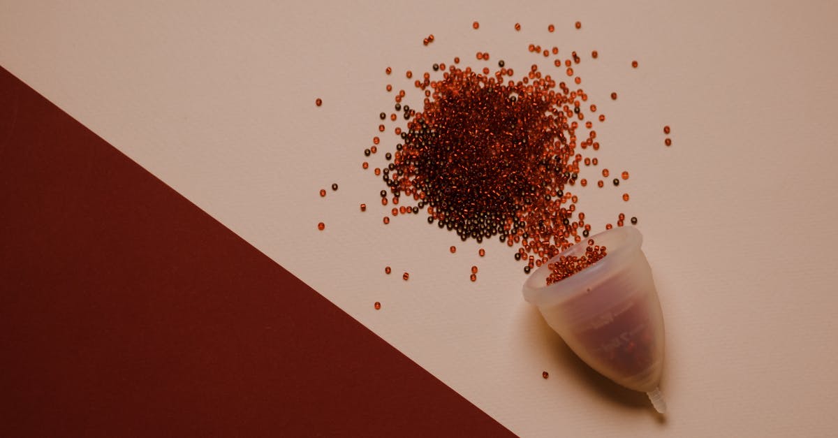 What is going on with Captain Marvel's blood colour? - Top view of silicone menstrual cup with red beads scattered on pink surface