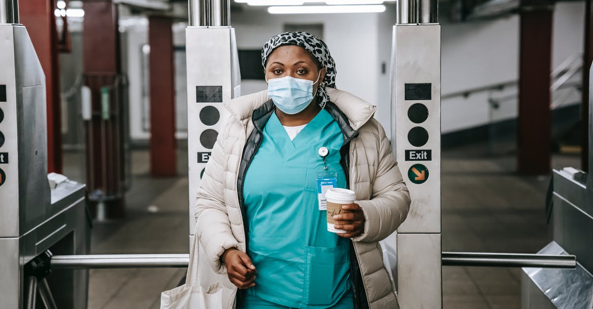 What is Mike Milligan's new job at the end of Fargo Season 2? - Calm adult African American nurse with coffee to go wearing warm outfit and protective face mask passing through turnstile in metro station and looking at camera