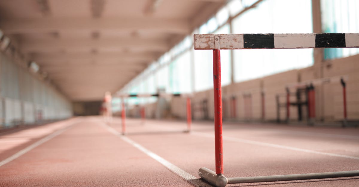 What is Red's motivation? - Hurdle painted in white black and red colors placed on empty rubber running track in soft focus