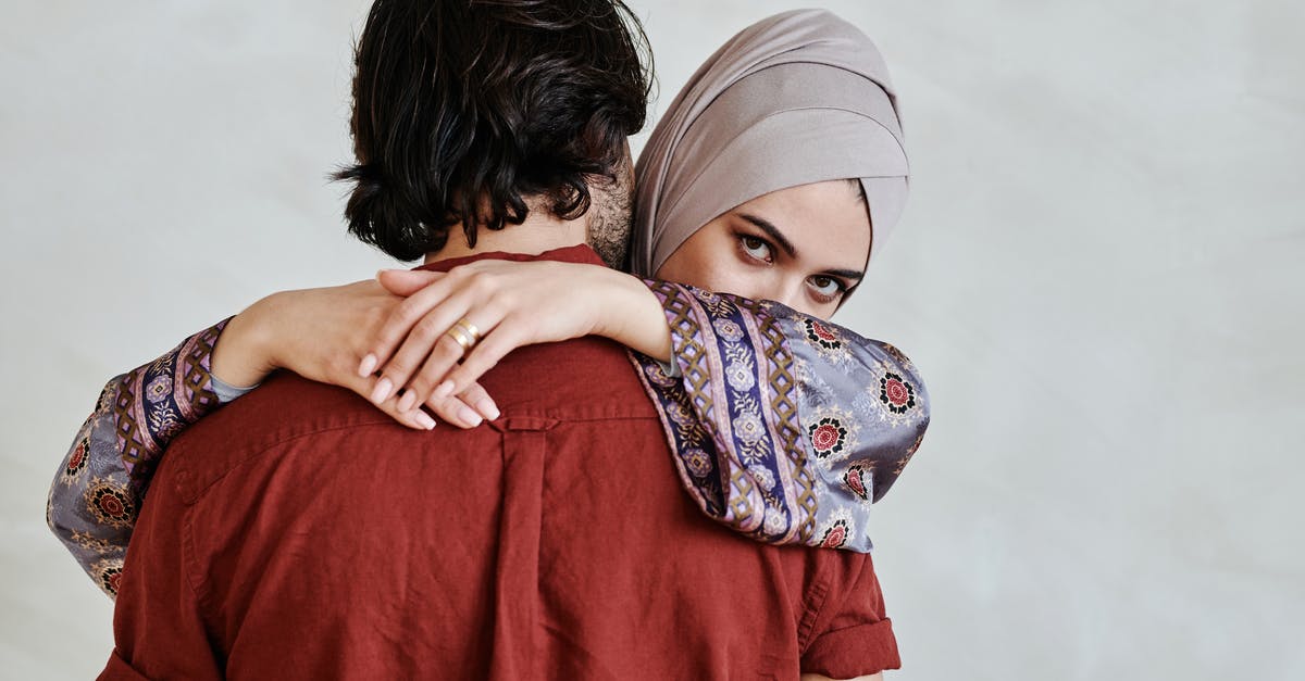What is Spider-Man wearing on his hand? - Woman in Hijab Hugging a Man Wearing Red Shirt