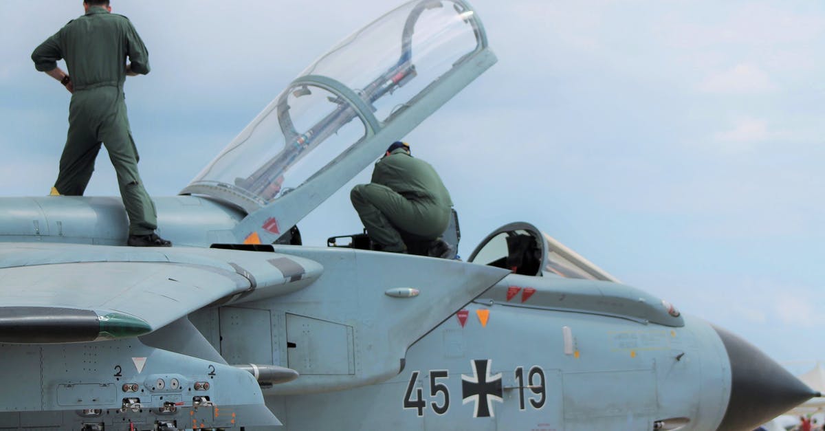 What is the approximate age of Captain Jack Sparrow? - Low angle of unrecognizable male pilots in uniforms standing on aged gray multirole combat aircraft before flight against cloudy sunset sky