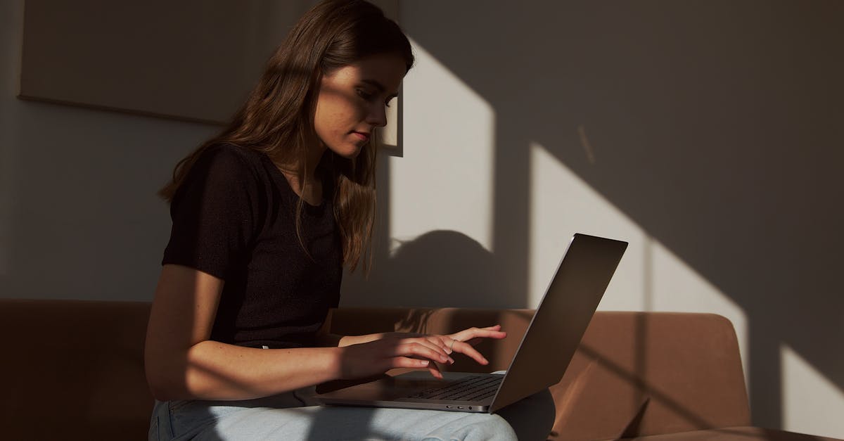 What is the connection between The Phantom Menace (1999) and The Shadow (1994)? - Serious young female in casual outfit sitting on cozy couch and typing on contemporary netbook in shadow light
