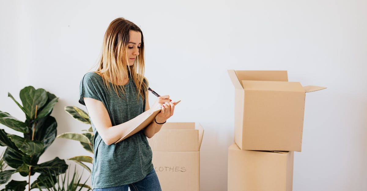 What is the content of the one un-opened package in "Castaway"? - Focused young lady in casual wear taking notes in clipboard while standing near packed carton boxes before moving into new house