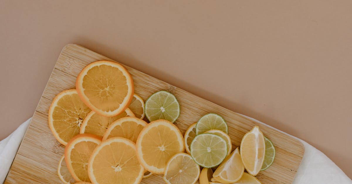 What is the difference between the beige and orange prison uniforms? - Top view of sliced with yellow lemons near oranges and green limes on wooden cutting board on white napkin on beige surface in light place