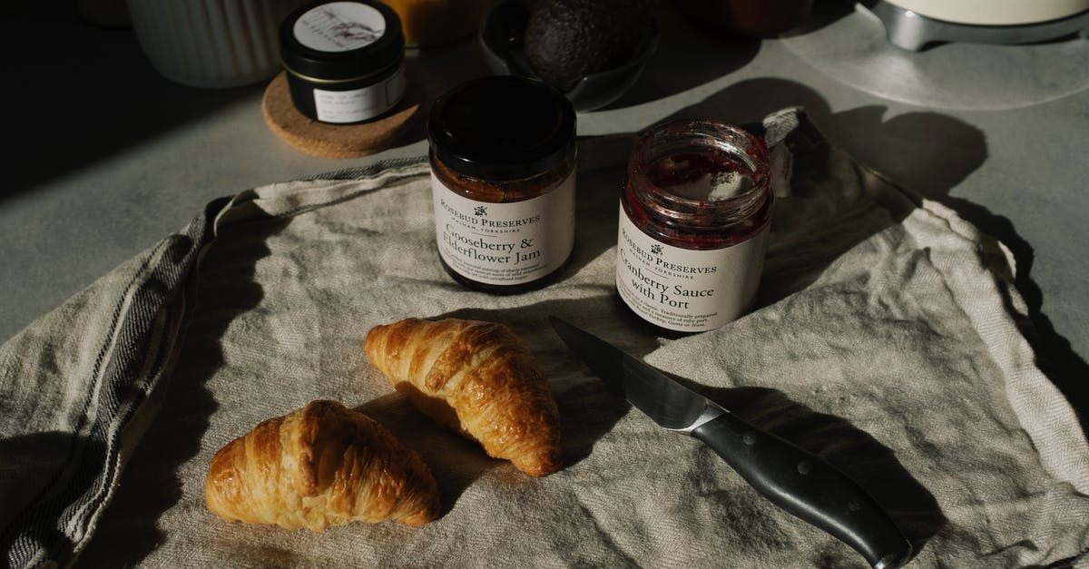 What is the English translation of the French dialogue in "Croissant de Triomphe"? - Still life of delicious brown croissants with opened jam and sauce pots on gray kitchen counter placed on with fabric napkin near knife in rustic style