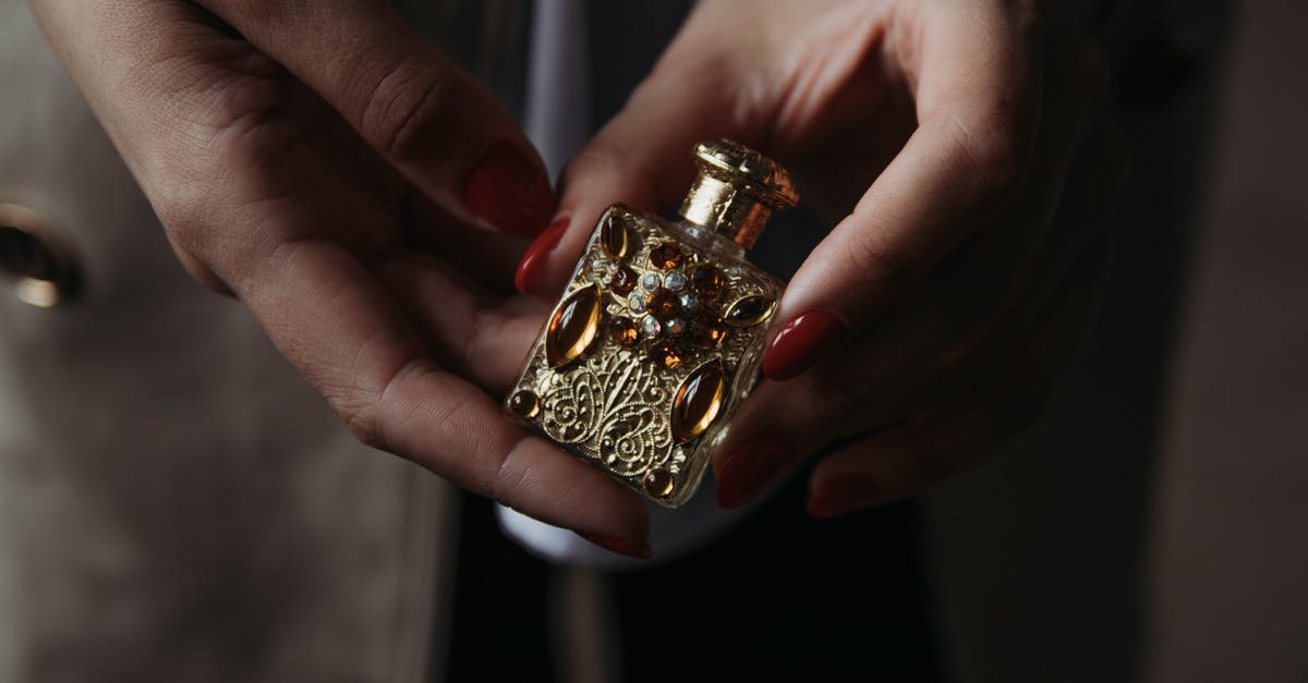 What is the history behind Scotty's hidden freezer and bottle of Scotch? - Crop faceless female with red manicure demonstrating small vintage golden perfume bottle decorated with natural stones and carved details