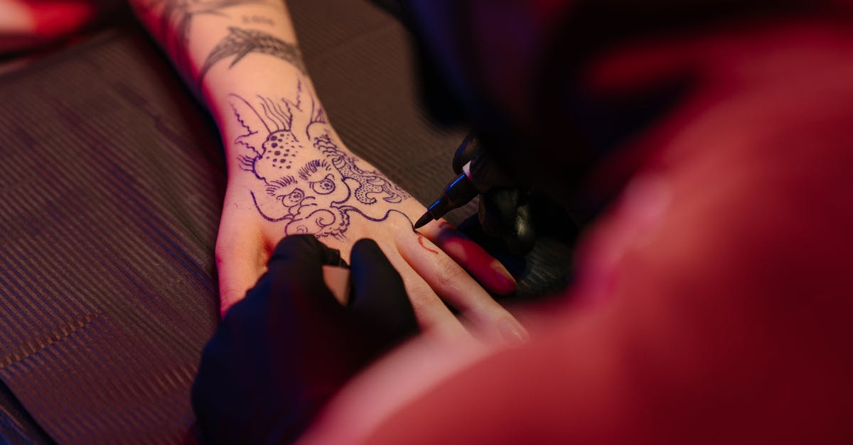 What is the importance of the dragon tattoo? - Person With Black Tattoo on Left Hand