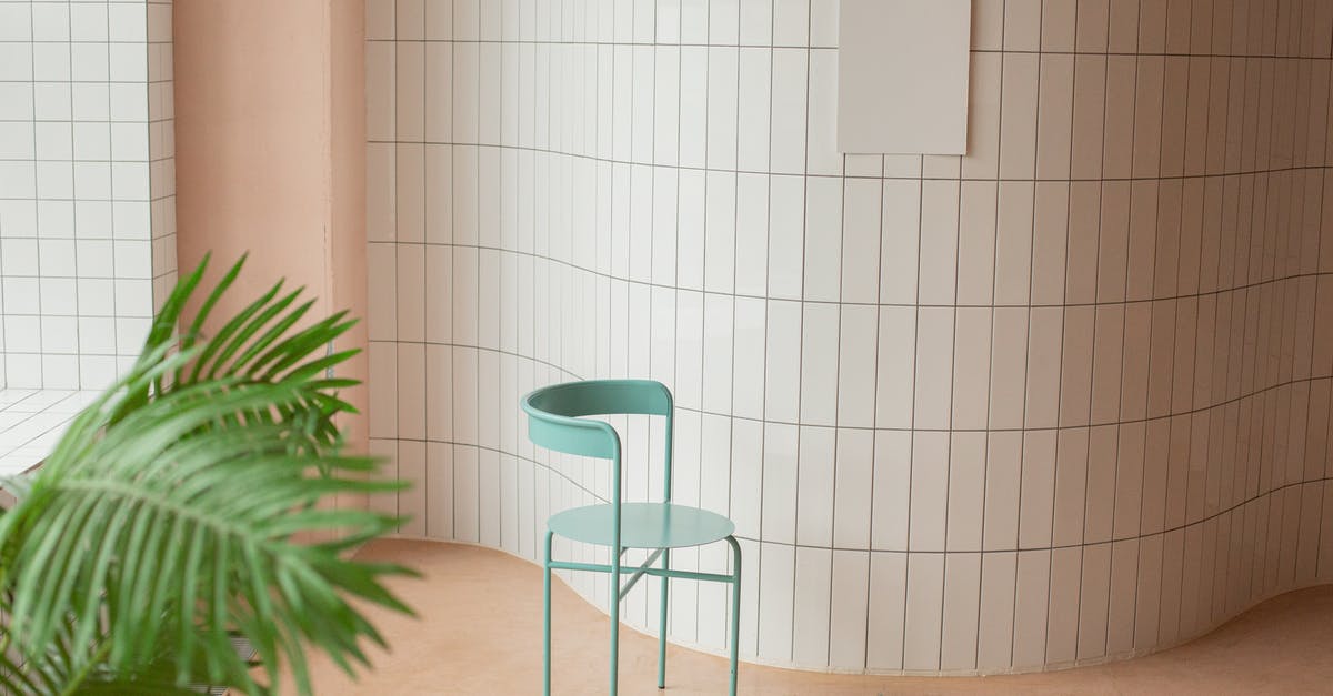 What is the interior location where Spectre has its board meeting? - Empty bright room with white canvas placed on tile wall near chair and green potted plant