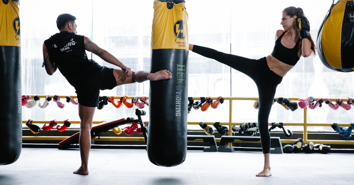 What is the meaning of physical pain in "Fight Club"? - Fit man and woman practicing kickboxing in gym