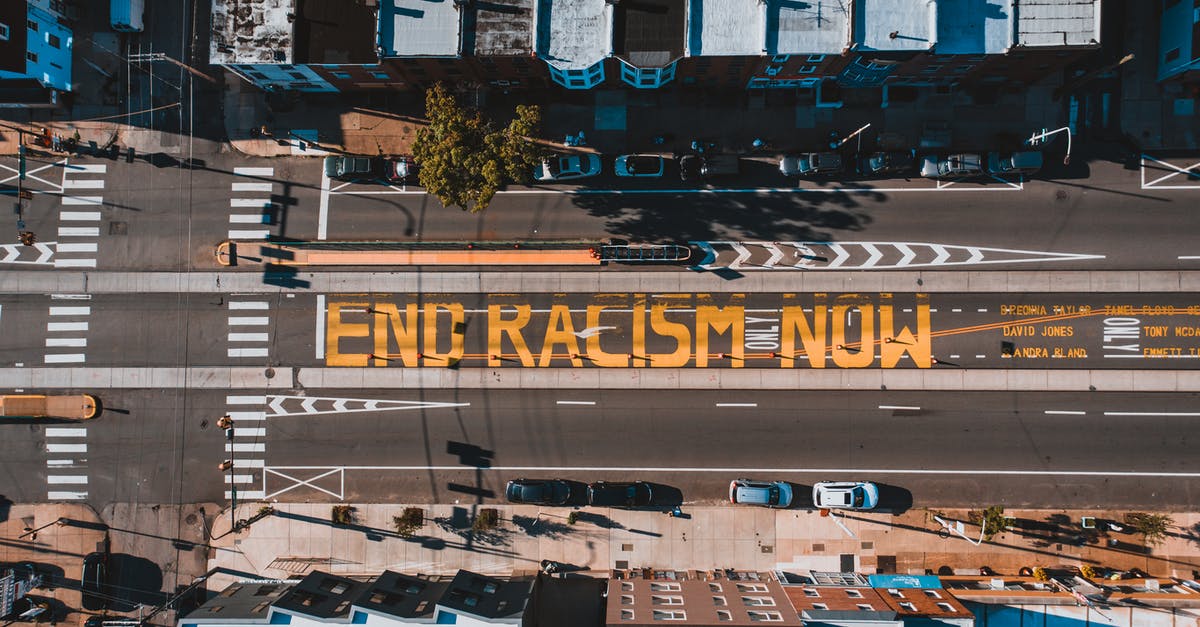 What is the meaning of this ending line? - Roadway with END RACISM NOW title in town