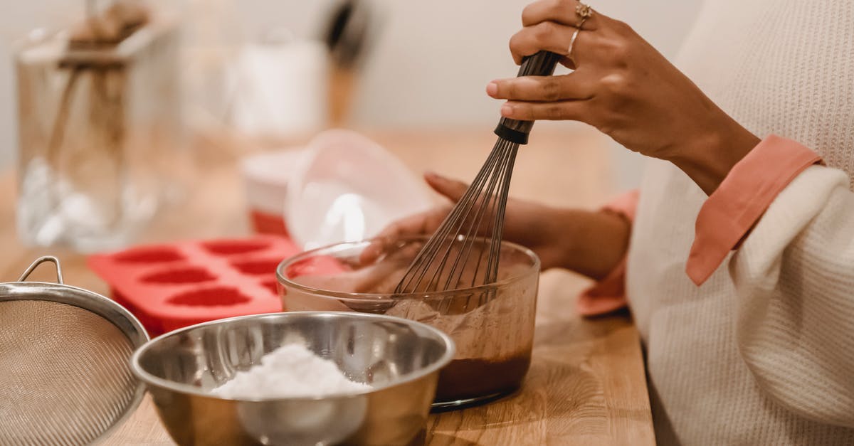 What is the metal that was melted in episode 1? - Side view of crop anonymous African American female whisking melted chocolate near metal bowl with flour in kitchen