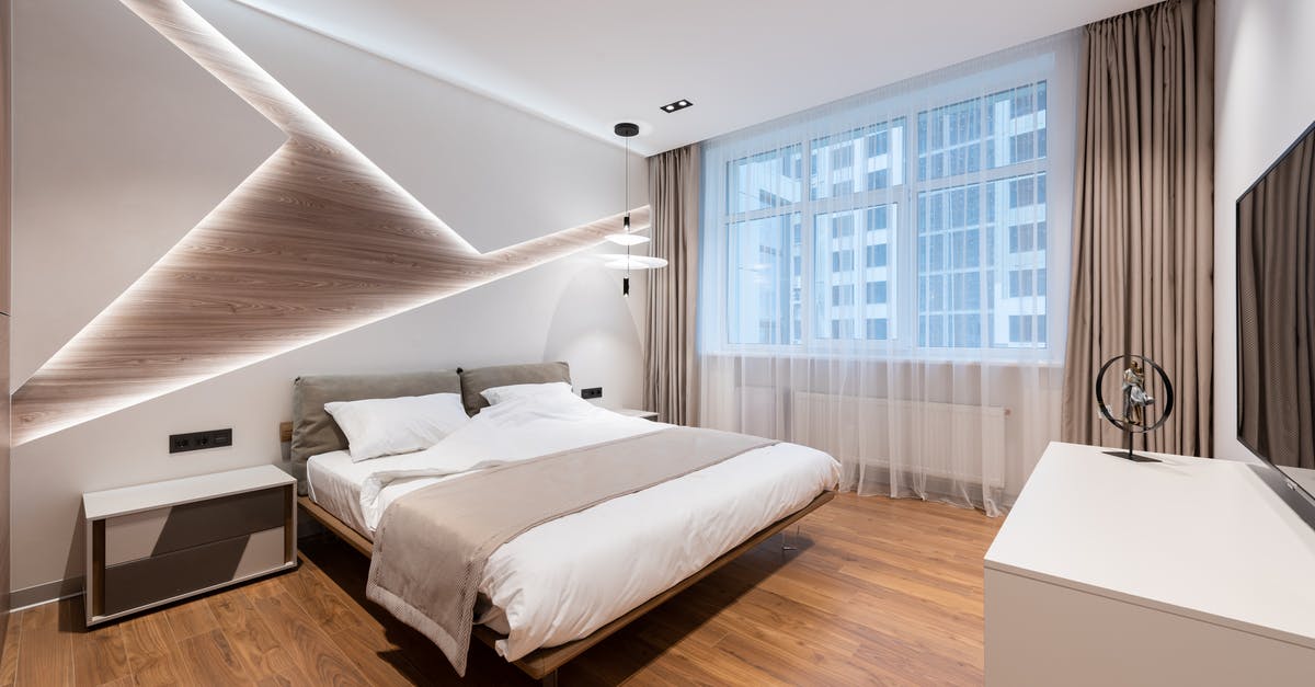What is the object found by the bed? - Interior of modern bedroom in hotel