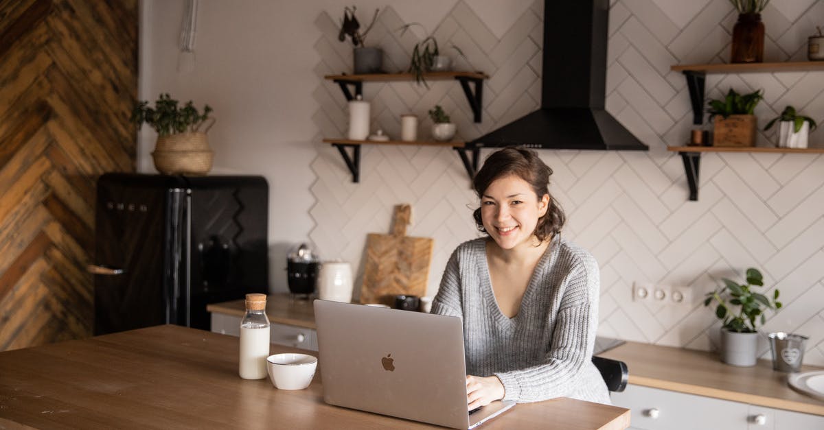 What is the order and time passed between the segments? - Cheerful female in casual clothes sitting at table with laptop and bottle of milk while browsing internet on laptop during free time at home and smiling looking at camera