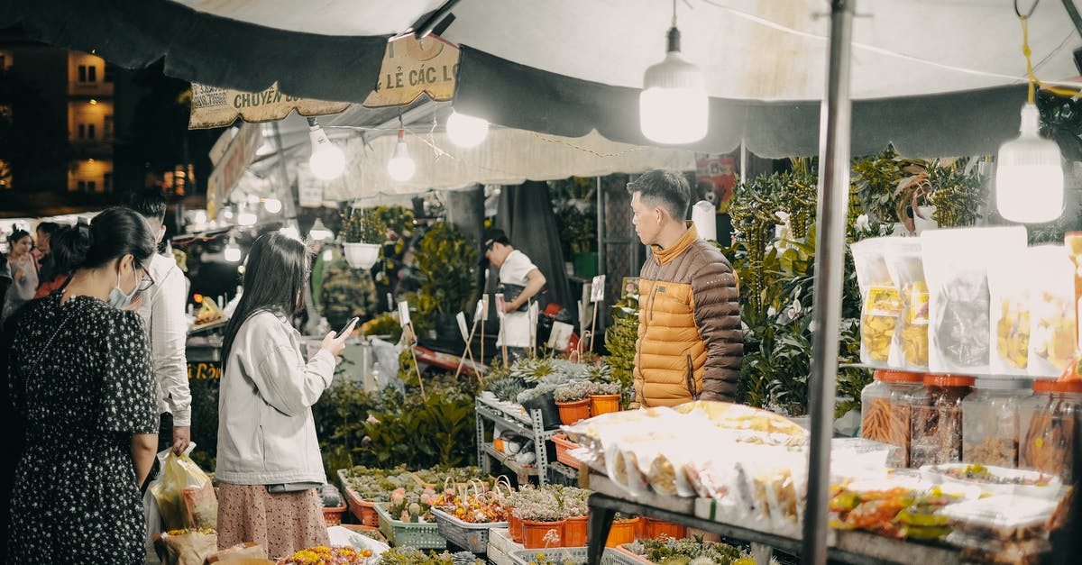 What is the origin of the “double entendre” stock footage trope? - A Woman Holding a Cellphone Standing in Front of Food Stall