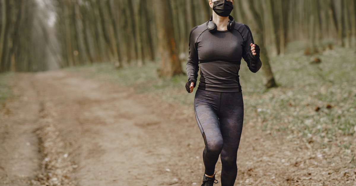 What is the origin of the Virus in the Maze Runner series? - Fit woman in sportswear and mask jogging along forest alley during virus outbreak