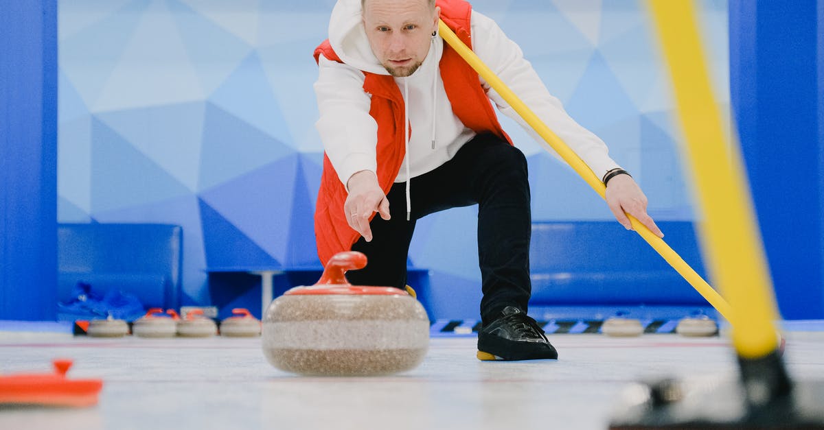 What is the point of throw the rock? - Determined sportsman in sportswear with special broom in hand throwing granite curling stone sliding on ice sheet while playing game