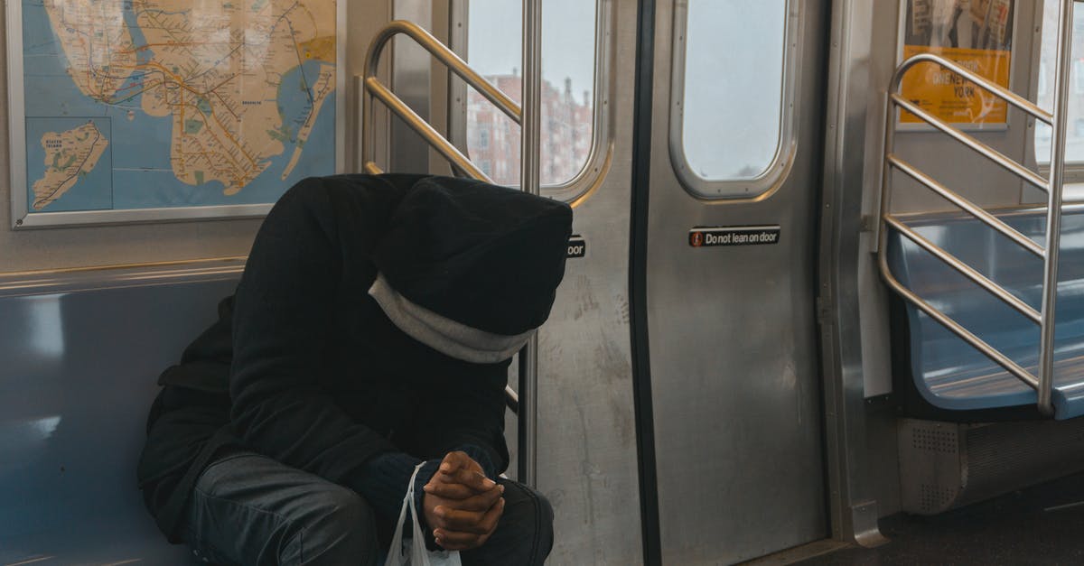 What is the significance of a man sitting on the train engine in the last scene of "Live and Let Die"? - Person in Black Hoodie Sitting on Train Bench