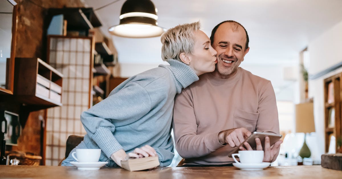 What is the significance of Frank watching Lucas kiss Zoe? - Enamored woman with short blond hair in warm sweater kissing cheek of happy ethnic husband using tablet during breakfast at home