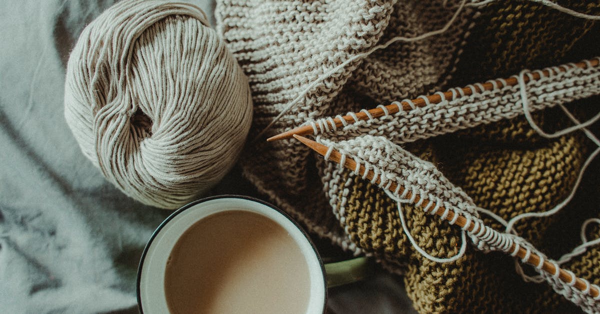 What is the significance of Shasta soft drinks? - From above of cup of hot coffee placed on bed with handmade knitted plaid with needles and wool yarn