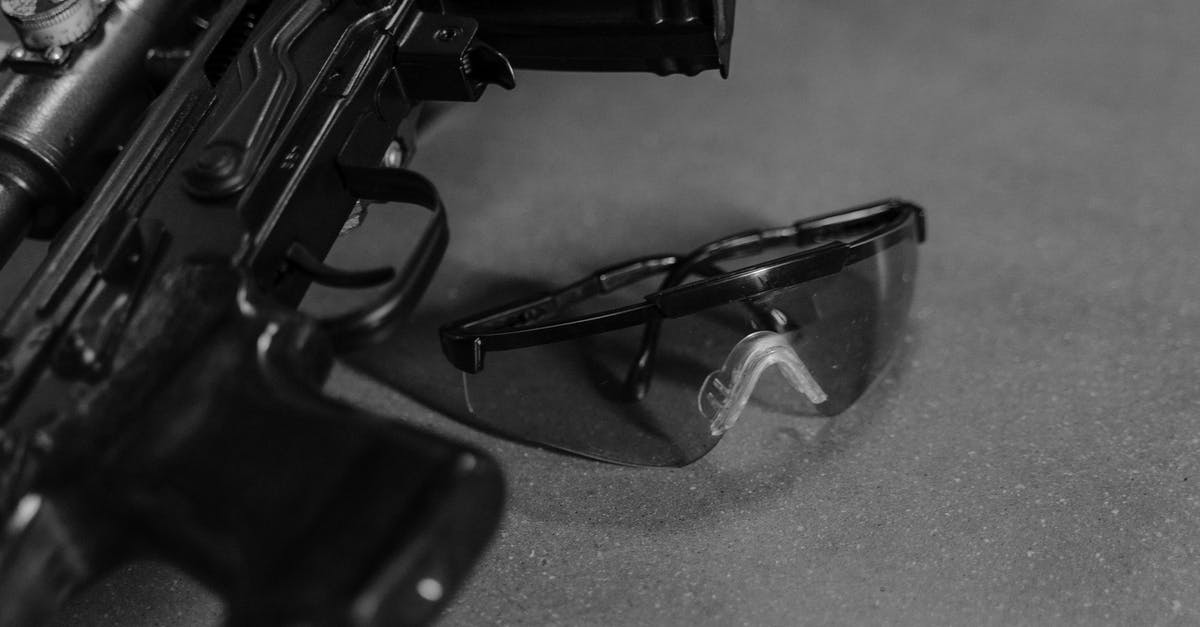 What is the significance of shooting through the glass? - Safety Glasses next to a Rifle