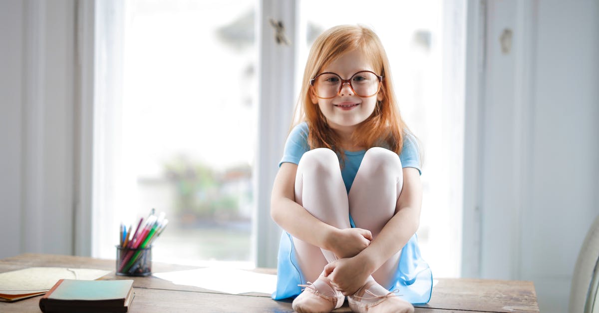 What is the significance of the book names' appearances? - Joyful red haired schoolgirl in blue dress and ballet shoes smiling at camera while sitting on rustic wooden table hugging knees beside school supplies against big window at home