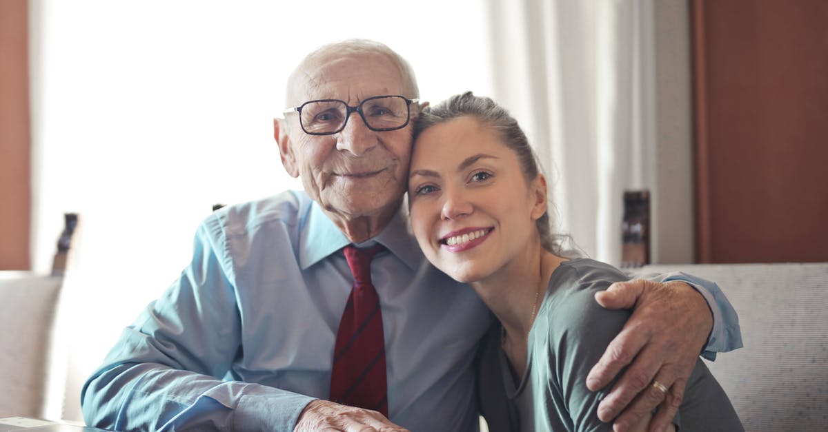 What is the term for this kind of final scene? - Positive senior man in formal wear and eyeglasses hugging with young lady while sitting at table