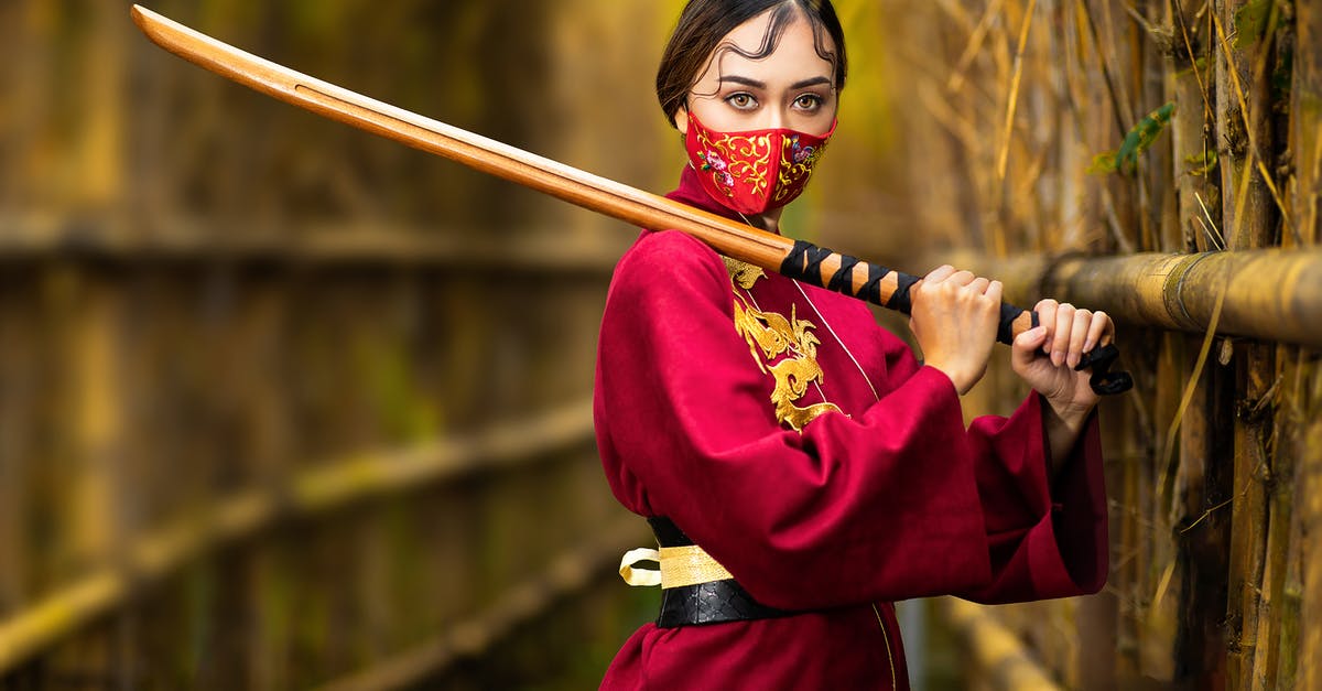 What is the village in Shichinin no Samurai (7 Samurai) called? - Anonymous focused female in face mask and bright wear standing with bamboo shinai on bridge while looking at camera