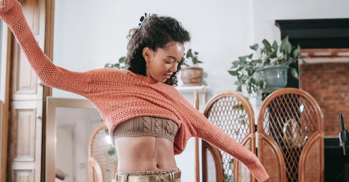 What is this golden belt that is given to Chewbacca? - Positive African American female with dark curly hair wearing beige knitted top and leggings with golden belt putting on light orange sweater