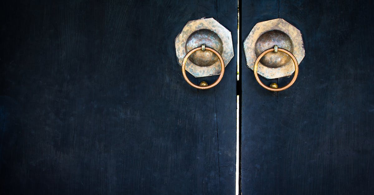 What substance does The Jackal spray onto the door handle? - Closed Black Wooden Door