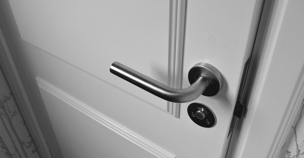 What substance does The Jackal spray onto the door handle? - Semi Open White Wooden Door