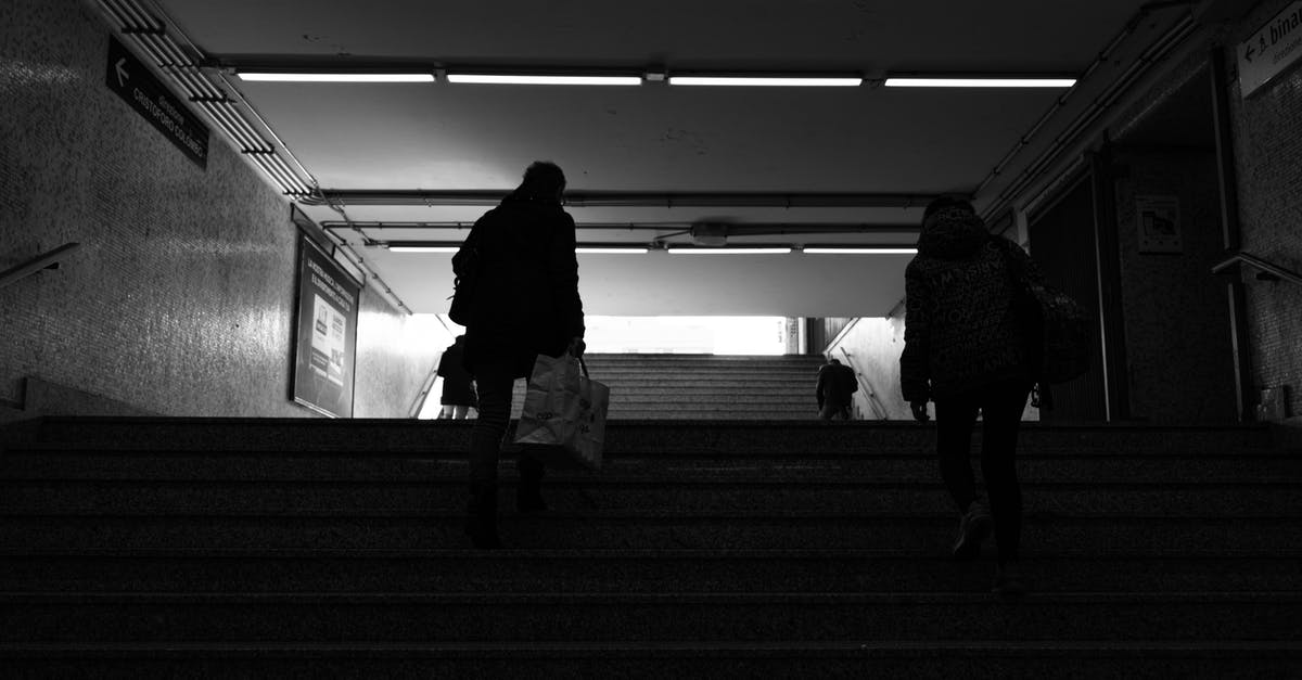 What was going on in the town after dark in 1917? - Back view black and white of anonymous passengers walking up staircase leaving subway station