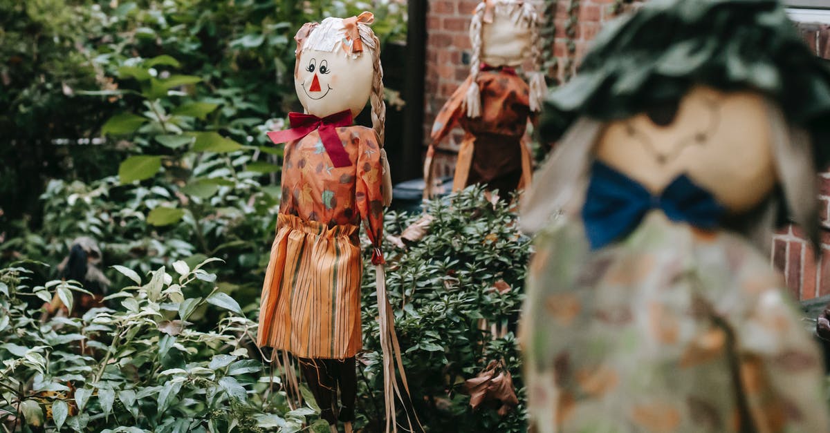 What was the Publisher character trying to be a symbol of in "Mother!"? - Terrible figurines of fictional characters near entrance of brick building with lush vegetation on Halloween