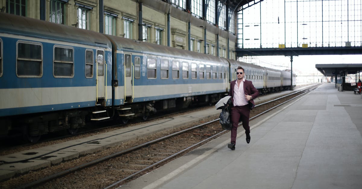 What was the train really running on in Snowpiercer? - Man in a Purple Suit Running Beside Blue and White Train