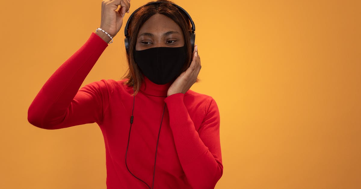 What was the well-known Russian song Lean wanted for Doctor Zhivago? - Content African American female wearing black protective mask listening to favorite music in headphones on yellow background in light studio