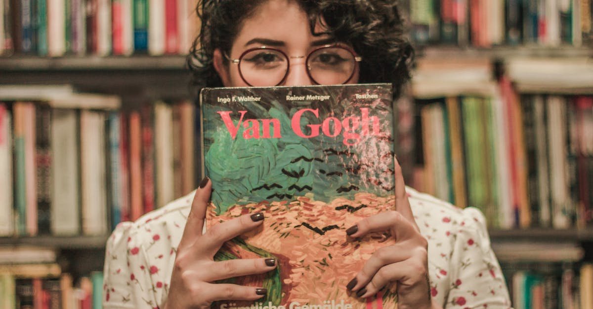 What was up with the lady in library? - Shallow Focus Photo of a Woman Holding Van Gogh Book