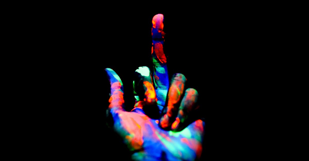 What was wrong with Betty's hands? - Crop anonymous persons hand painted with multicolored bright neon colors showing middle finger in obscurity